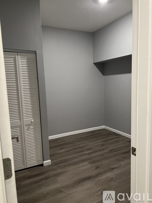 A room with a white door and a grey wall.
