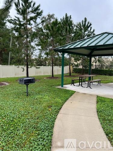 A green and white pavement with a bench and a mailbox.