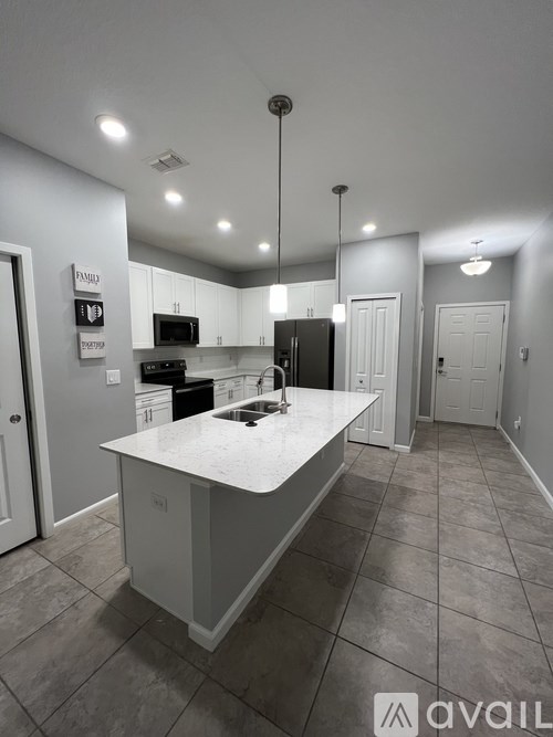 A kitchen with a white island in the middle of the room.