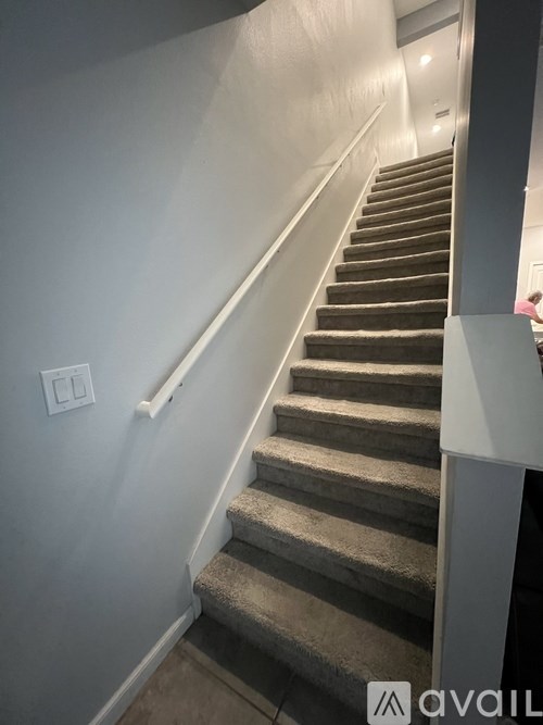 A staircase with a light switch on the wall.