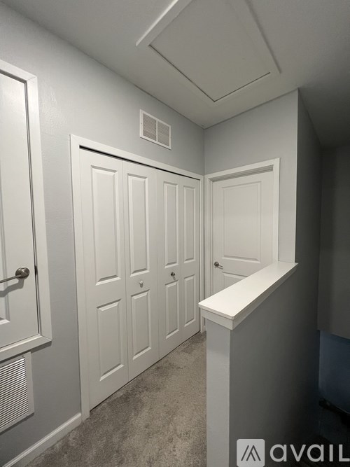 A hallway with white doors and a white reception desk.
