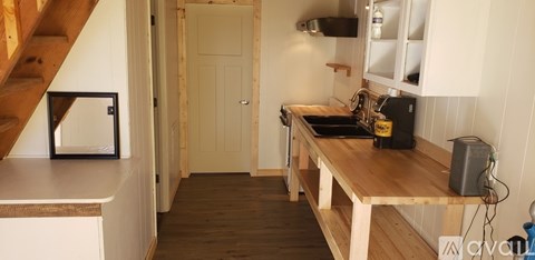 A small kitchen with a wooden table and a microwave on it.