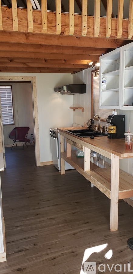 A kitchen with wooden floors and a wooden ceiling with exposed beams.