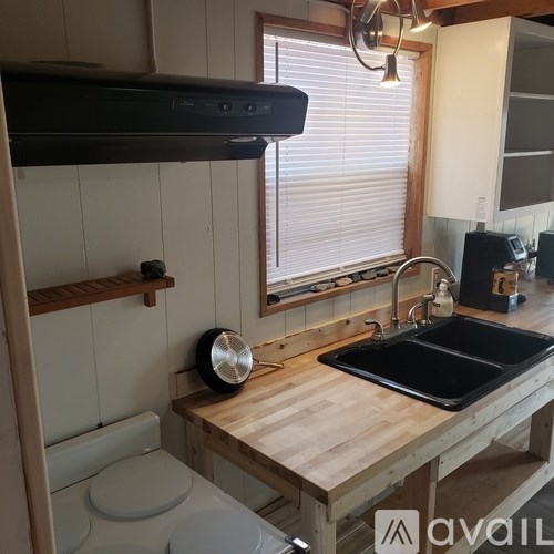 A kitchen with a wooden counter and a fan on it.