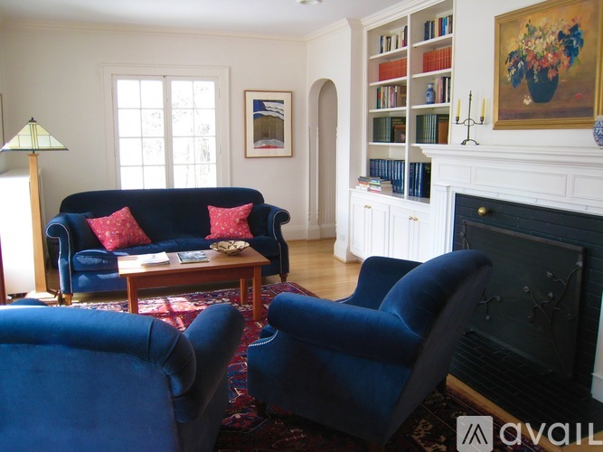A living room with a blue couch and two blue chairs.