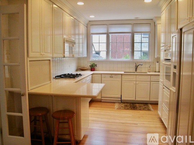 A kitchen with white cabinets and a window.
