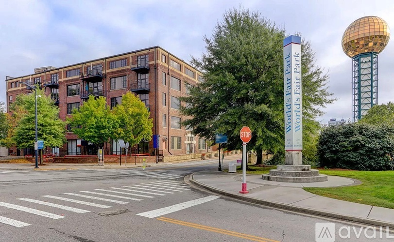 A street view with a stop sign and a tall tower in the background.