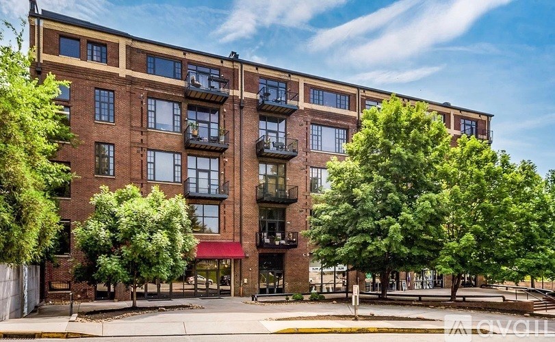 A large brick building with a red awning and balconies.
