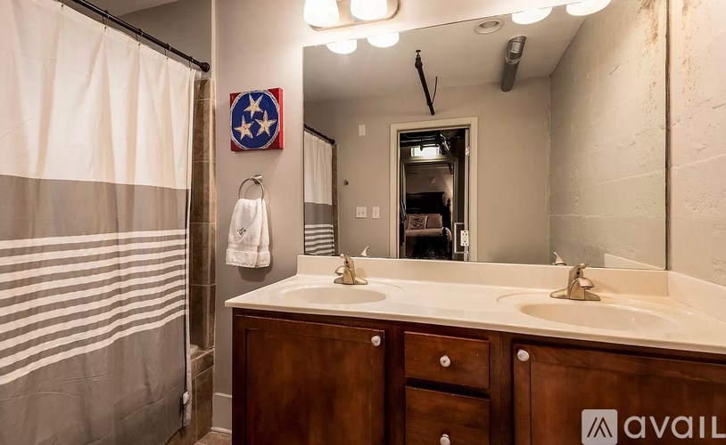 A bathroom with a white counter top and a brown cabinet.