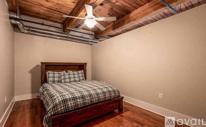 A bedroom with a bed and a ceiling fan.