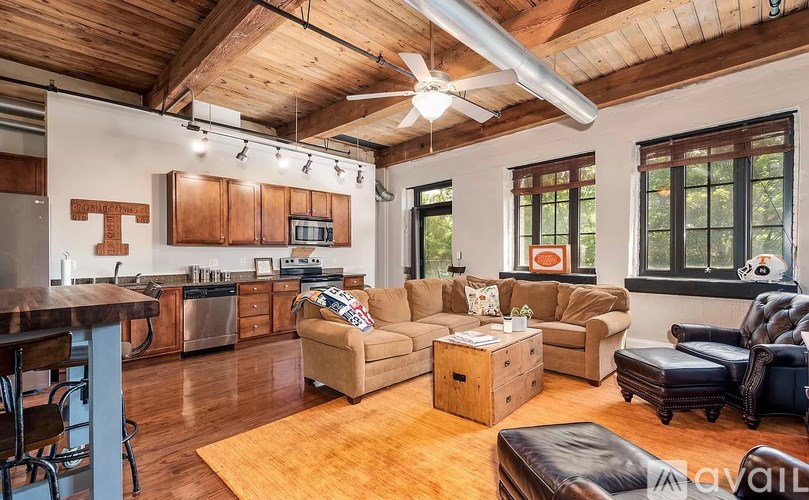 A living room with a kitchen area in the background.