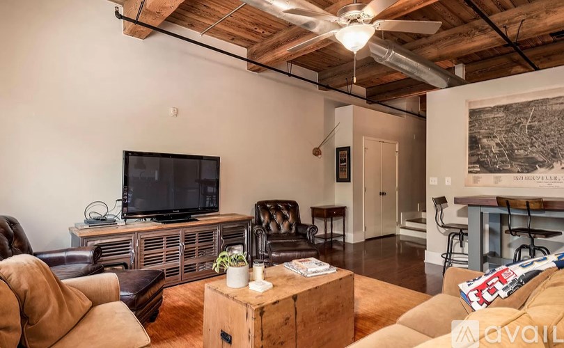 A living room with a brown leather couch and a wooden coffee table.