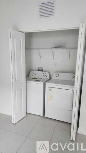 A white laundry room with a washer and dryer.