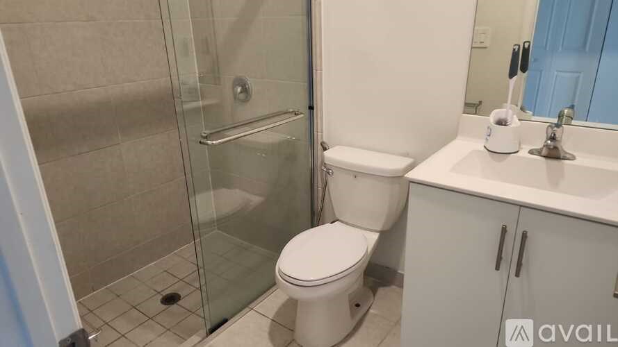 A bathroom with a toilet, sink, and glass shower stall.