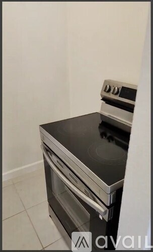 A stainless steel oven with a black countertop is installed in a kitchen.