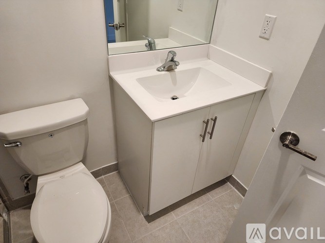 A white toilet sits next to a sink in a small bathroom.