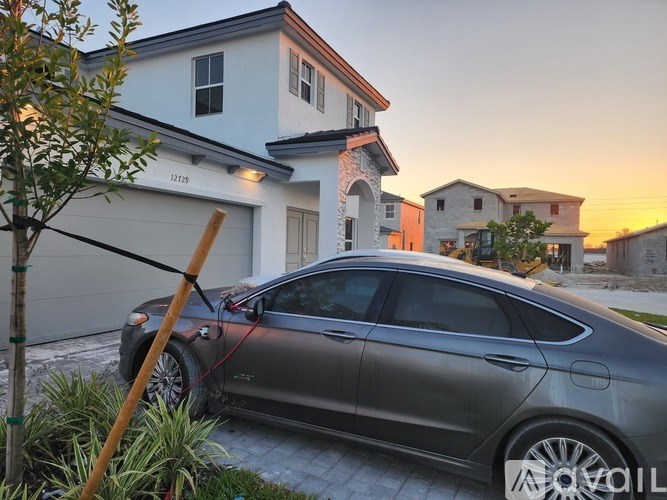 A silver car is parked in front of a house.