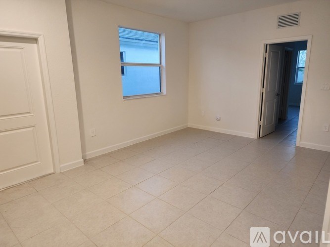 A room with a tiled floor and a window letting in light.