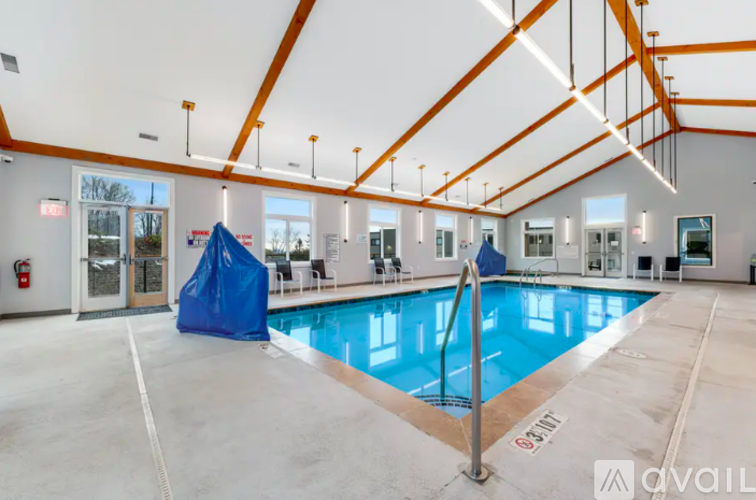 A large indoor swimming pool with a blue cover and a diving board.