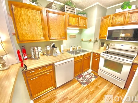 A kitchen with wooden cabinets and a white dishwasher.