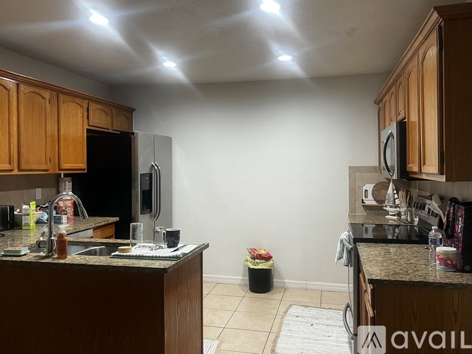 A kitchen with brown cabinets and a granite countertop.