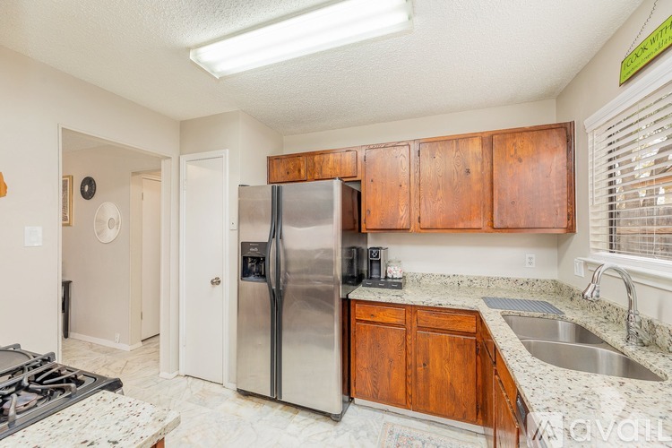 A kitchen with a stove top oven and a refrigerator.