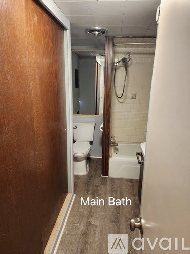 A bathroom with a wooden door and a main bath sign.