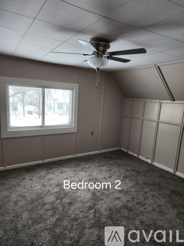 Bedroom 2 with a ceiling fan and carpeted floor.