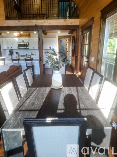A long wooden table with a vase of flowers in the middle of it.