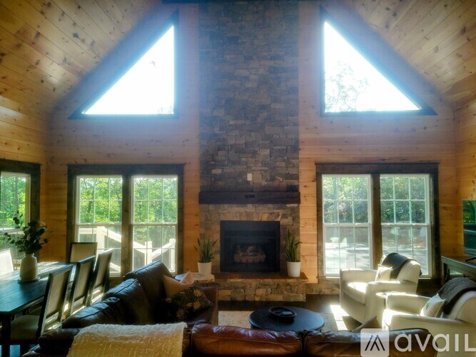 A cozy living room with a fireplace and large windows.