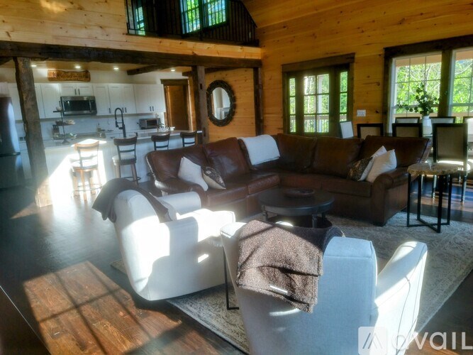 A living room with a brown couch and a wooden floor.