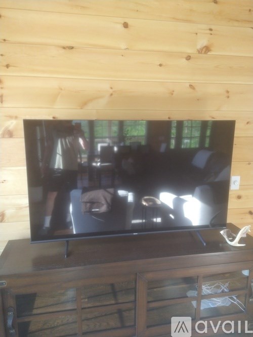 A flat screen TV mounted on a wooden wall.