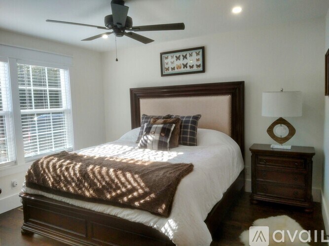 A bedroom with a large bed and a ceiling fan.