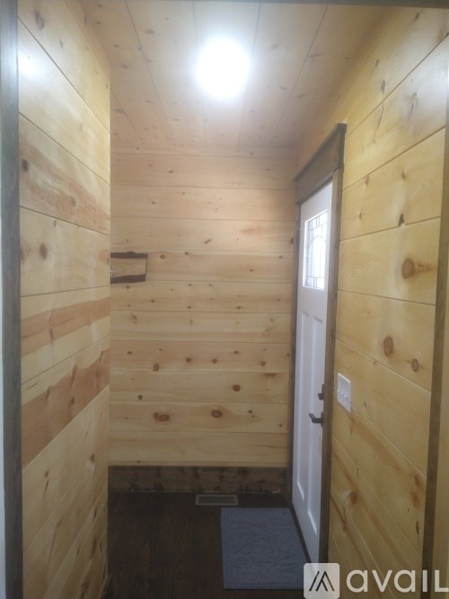A wooden hallway with a door on the right.