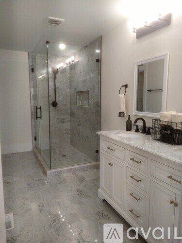 A bathroom with a marble floor and a walk-in shower.