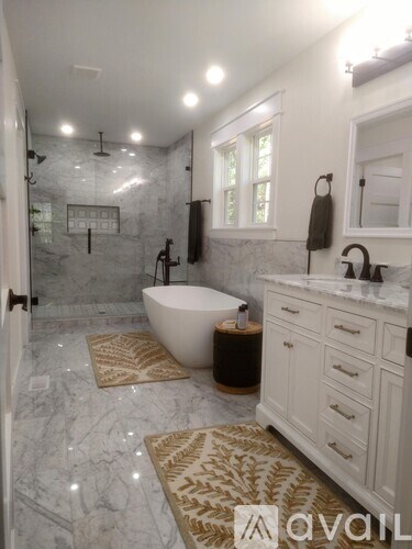 A bathroom with a marble floor and a white bathtub.