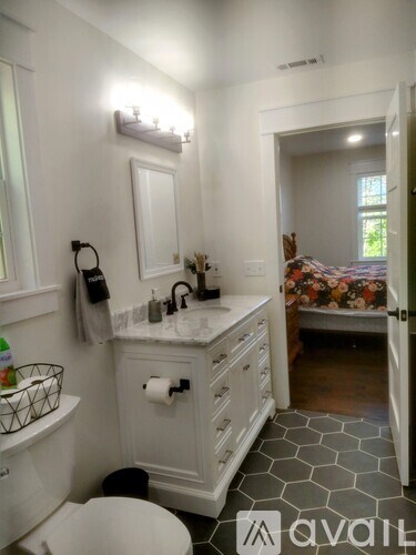 A bathroom with a toilet, sink, and mirror.