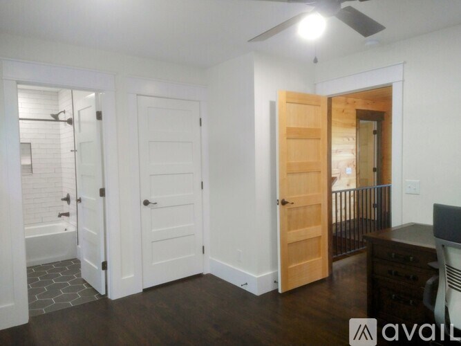 A room with a ceiling fan and a desk with a chair.