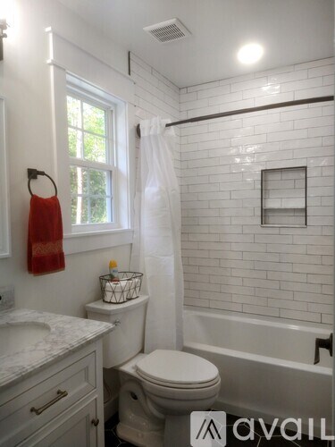 A white bathroom with a toilet, sink, and tub.