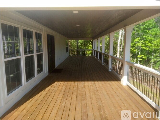 A wooden deck with a white railing and a white ceiling.