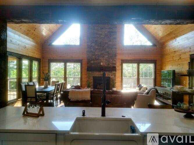 A kitchen with a large island and a fireplace in the background.