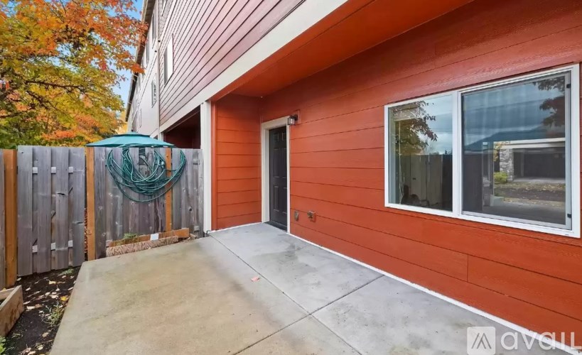 A red house with a brown fence and a blue hanging decoration.