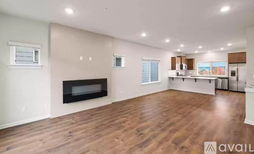 A spacious living room with a fireplace and hardwood floors.