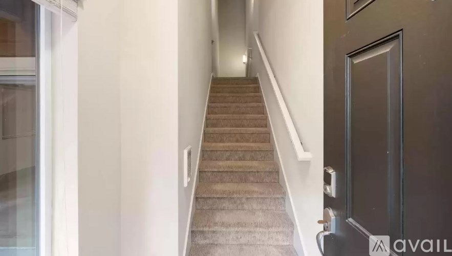 A staircase with a carpeted runner and a metal handrail.