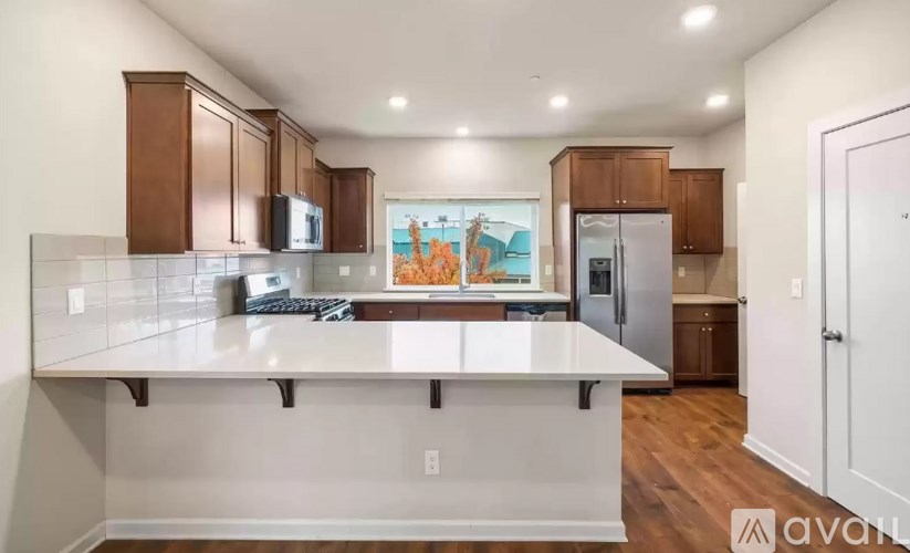 A kitchen with white countertops and wooden cabinets.