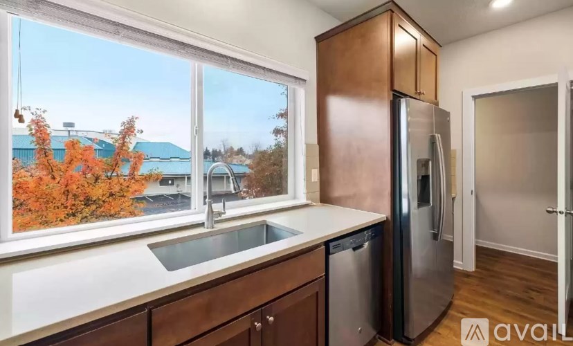 A kitchen with a refrigerator, sink, and cabinets.