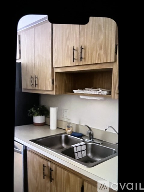 A kitchen with wooden cabinets and a stainless steel sink.