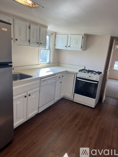 A kitchen with white cabinets and a stainless steel refrigerator.