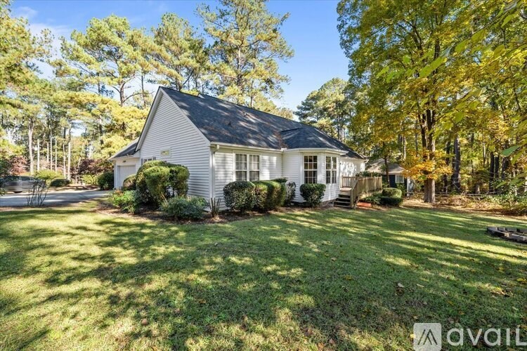 A house with a well-kept lawn and trees in the background.
