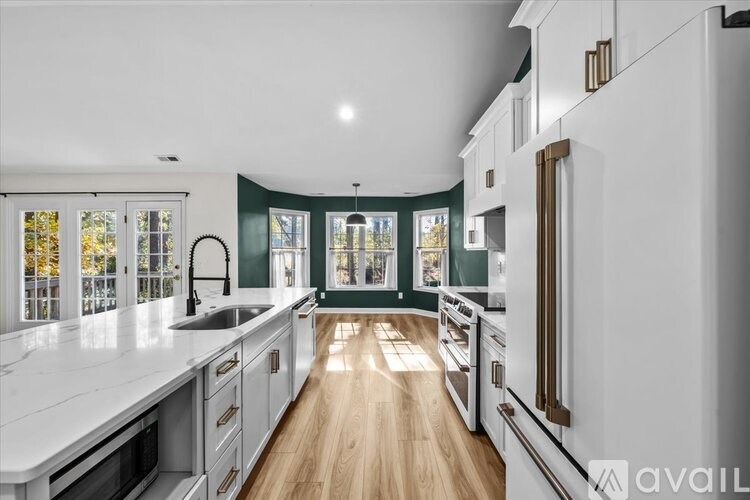 A modern kitchen with white countertops and stainless steel appliances.